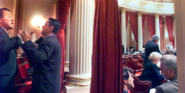 DEBATE --- What is it like documenting sessions of the Senate and Assembly from inside the chambers? I am often asked the question and the answer is the same, "It is like flying an airplane: 99% of the time there isn't much action but every once in awhile..." I was standing in the back of the Senate this day, when I heard two people talking uncharacteristically loudly. Keith Olberg, a Republican assemblyman, left, was arguing with Gil Cedillo, a Democratic assemblyman. The resulting image captures the passion of politics.
August 31, 2000.