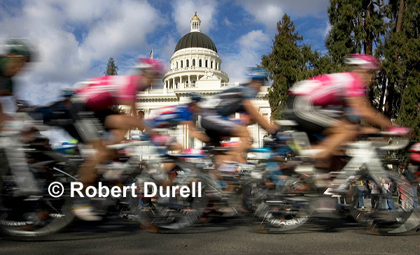 TOUR OF CALIFORNIA --- Bits of asphalt ricocheted off my cheeks, forehead and knuckles. I jammed the camera against my face, using it as protection for both of my eyes. Someone even stepped on my back as a lay prone at the corner of 11th and N Streets. The only way to get the Capitol dome in perfect position with the riders whizzing by during the Sacramento stage of Amgen Tour of California was to lie in the street. The goal was to situate the race clearly in the state's Capitol. Mission accomplished. February 20, 2007
