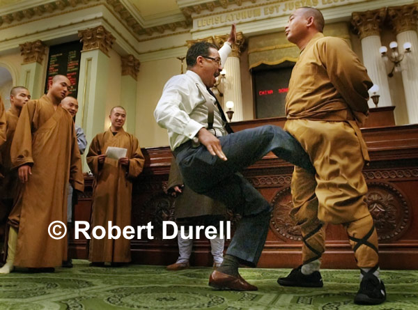 THE KICK --- I was in the Capitol for another assignment when a legislative staffer suggested I head to the Assembly floor.  The Assembly was not in session but a group of Shaolin Monks from Hunan province in China was getting a special tour. As I prepared to leave after 10 minutes of hum-drum photos, I heard the group's translator encourage Wesson to kick one the Monks in the crotch, a method they use to toughen themselves.  As Wesson approached the monk, I quickly dropped to the floor and stayed underneath a desk for a low angle shot. Wesson kicked three times, the monk never flinched, and I had one of my most memorable photos from a decade under the dome. 
March 22, 2004
