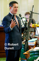 FIRED UP  ---  Sometimes photos tell a false story - or do they? I wasn't the only one who was a little nervous as Assemblyman Todd Spitzer brought very realistic toy guns to the Assembly floor that day. Everyone had been warned, and knew they were toys, but Spitzer's props still silenced the usually loquacious legislators.  He was seeking votes for a bill to ban the public display of such weapons. The fear was real and the scare tactic had its desired affect. His bill passed easily. 
August 15, 2004
